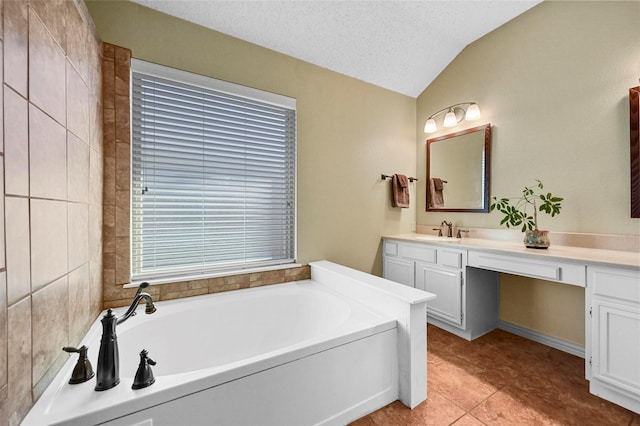 bathroom featuring a textured ceiling, vaulted ceiling, a bathtub, tile patterned flooring, and vanity