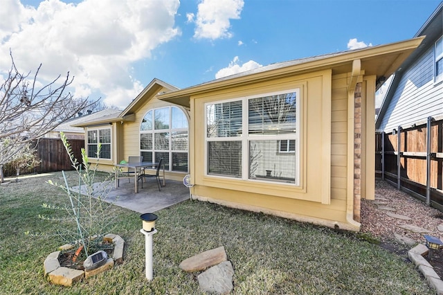 back of property with a lawn and a patio area