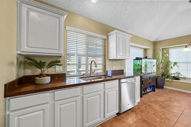 kitchen featuring sink, white cabinetry, stainless steel dishwasher, and a textured ceiling