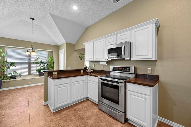 kitchen featuring lofted ceiling, stainless steel appliances, white cabinets, and a chandelier