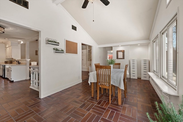 dining area featuring ceiling fan, ornamental molding, high vaulted ceiling, and sink