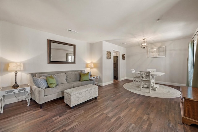 living room featuring dark wood-type flooring and a chandelier