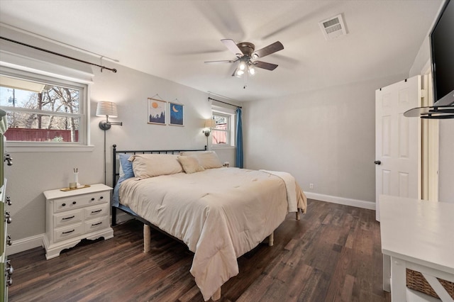 bedroom with ceiling fan, multiple windows, and dark hardwood / wood-style floors