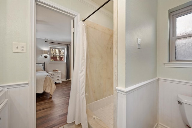 bathroom with toilet, hardwood / wood-style flooring, ornamental molding, and curtained shower