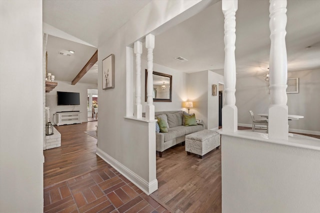 hallway with lofted ceiling with beams and decorative columns