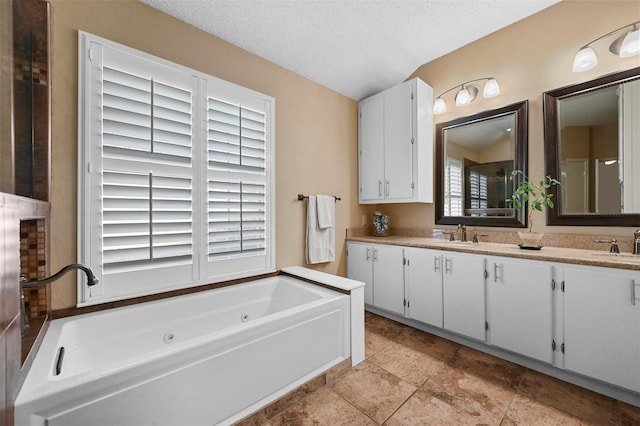 bathroom with vanity, a textured ceiling, and a bathing tub