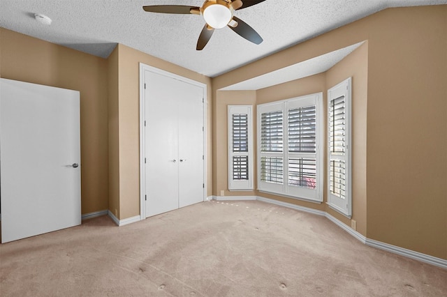 unfurnished bedroom with a closet, a textured ceiling, ceiling fan, and light colored carpet