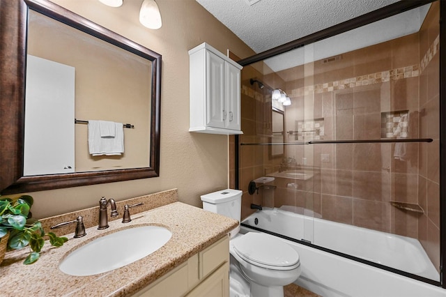 full bathroom featuring toilet, vanity, a textured ceiling, and bath / shower combo with glass door