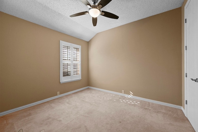 spare room with lofted ceiling, a textured ceiling, light colored carpet, and ceiling fan