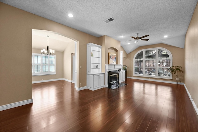 unfurnished living room with a textured ceiling, lofted ceiling, dark hardwood / wood-style flooring, ceiling fan with notable chandelier, and a fireplace