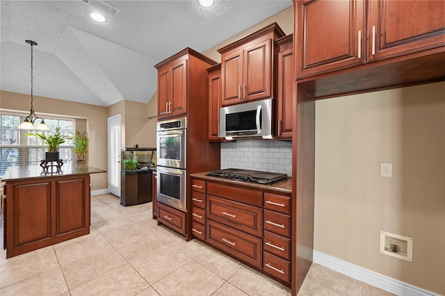 kitchen with lofted ceiling, stainless steel appliances, a textured ceiling, and tasteful backsplash