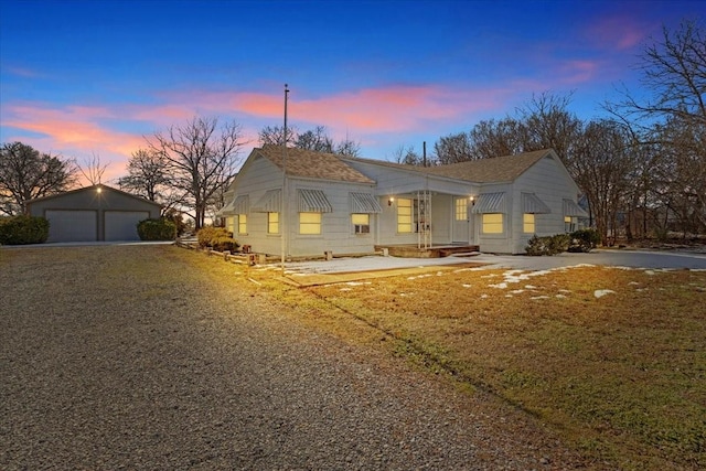 view of front of house with a garage and an outbuilding