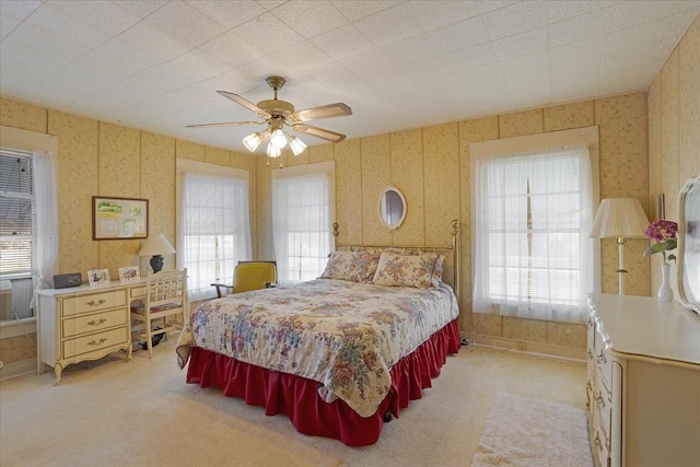 carpeted bedroom with multiple windows and ceiling fan