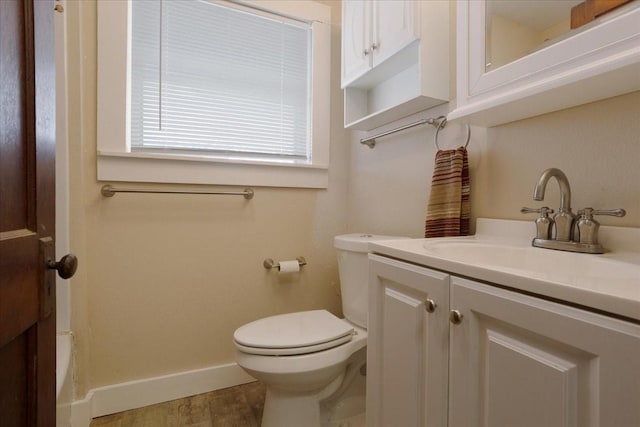 bathroom with toilet, vanity, and hardwood / wood-style floors