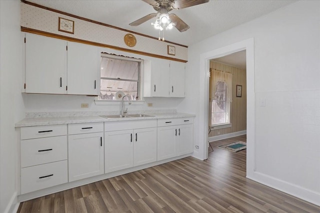 kitchen featuring white cabinets, light hardwood / wood-style floors, ceiling fan, a textured ceiling, and sink