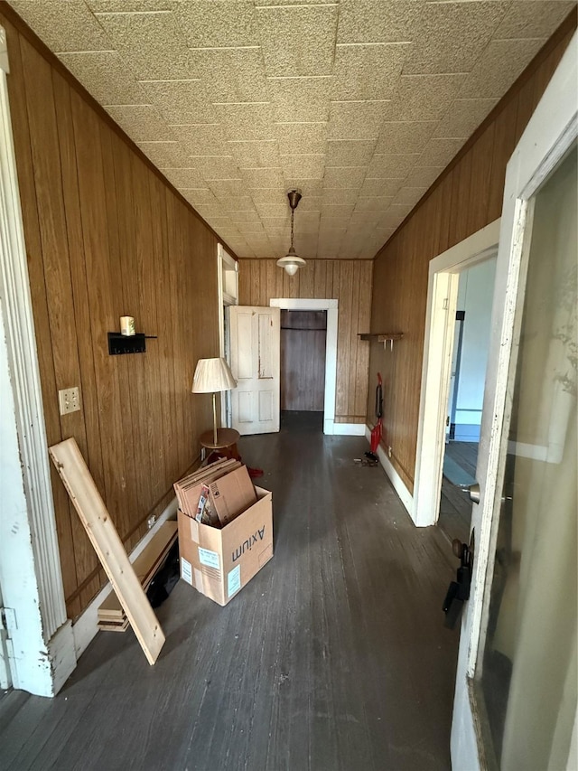 hallway featuring wood walls and dark hardwood / wood-style floors