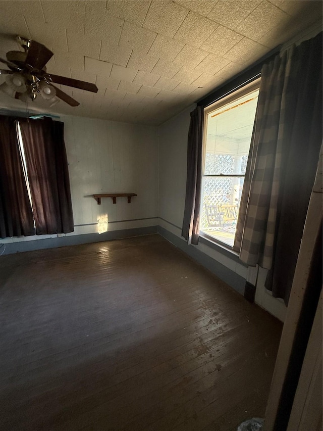 unfurnished room with ceiling fan and dark hardwood / wood-style flooring