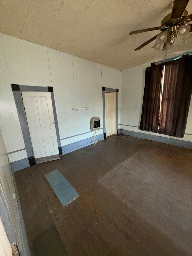 spare room with dark hardwood / wood-style flooring, ceiling fan, and heating unit