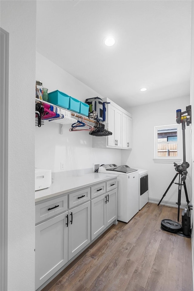 laundry area featuring light hardwood / wood-style floors, cabinets, and independent washer and dryer