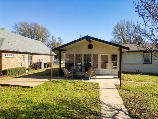 back of property featuring a patio and a lawn