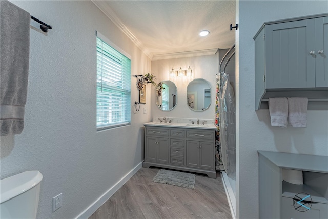 bathroom with toilet, vanity, hardwood / wood-style floors, and crown molding