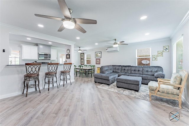 living room with light hardwood / wood-style floors, crown molding, and plenty of natural light