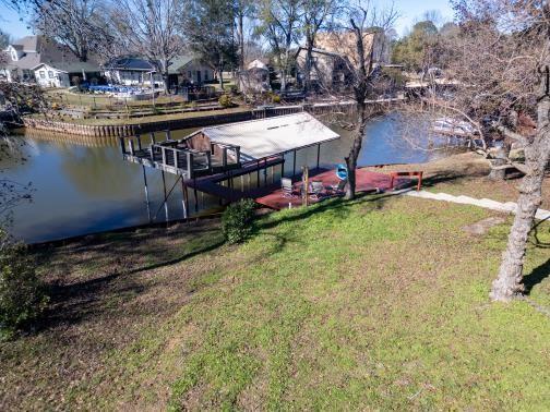 view of dock with a lawn and a water view