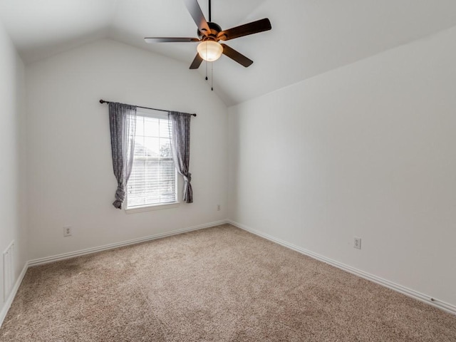 spare room with ceiling fan, vaulted ceiling, and carpet floors