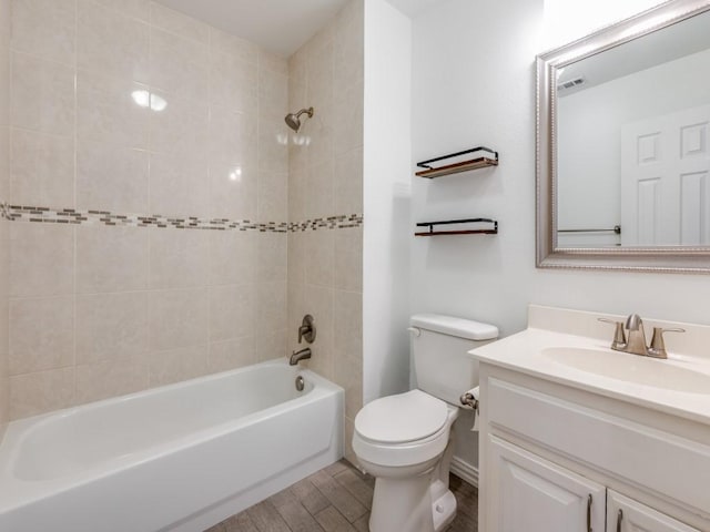 full bathroom featuring tiled shower / bath, toilet, vanity, and wood-type flooring