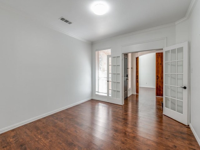 empty room with ornamental molding, dark wood-type flooring, and french doors