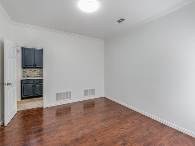 spare room featuring ornamental molding and hardwood / wood-style flooring