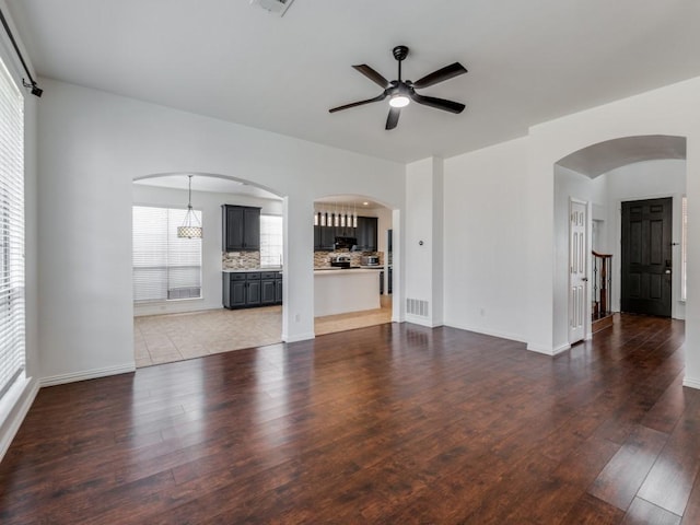 unfurnished living room featuring ceiling fan and wood-type flooring