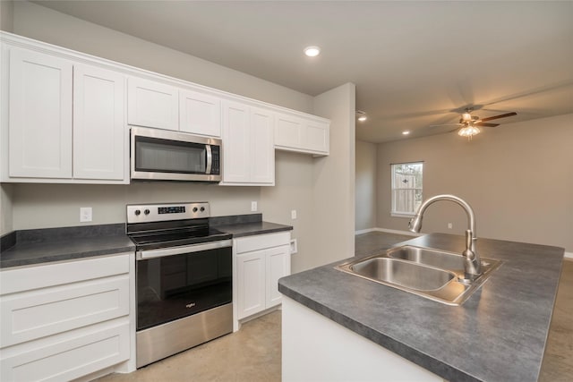 kitchen with an island with sink, white cabinetry, appliances with stainless steel finishes, ceiling fan, and sink