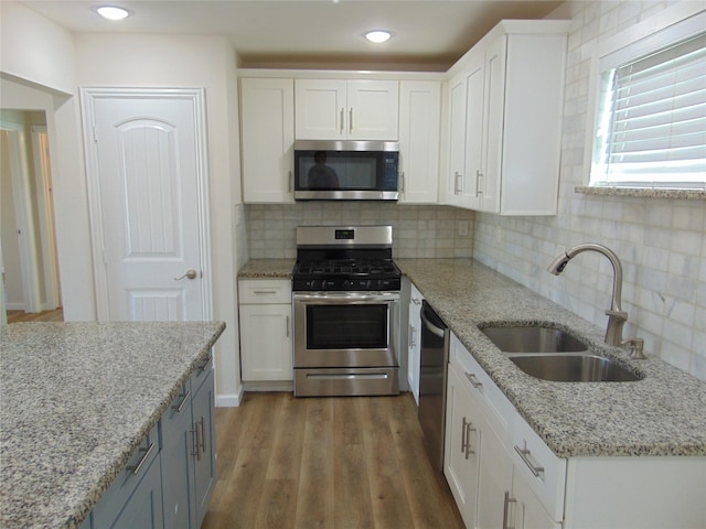 kitchen featuring sink, white cabinets, tasteful backsplash, and appliances with stainless steel finishes