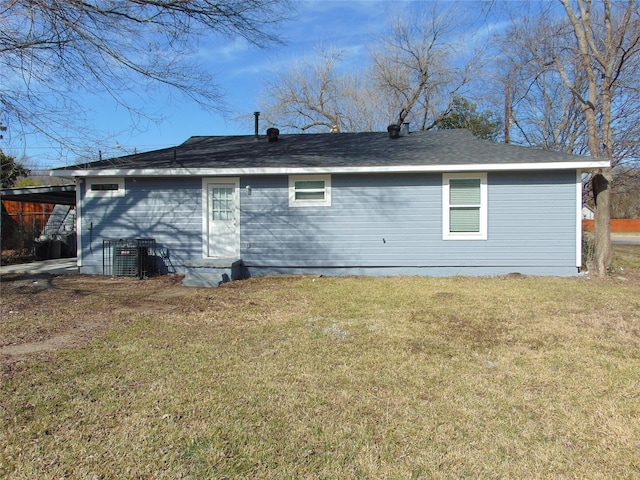 back of house featuring a yard, a carport, and central AC unit