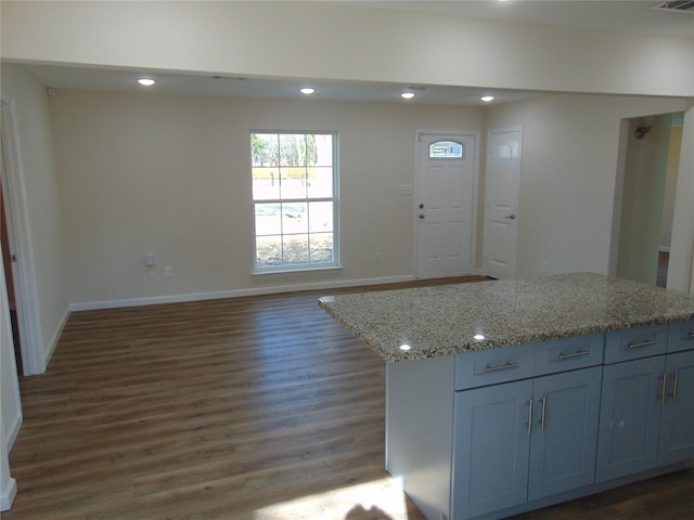 kitchen featuring a kitchen island, dark hardwood / wood-style flooring, and light stone countertops