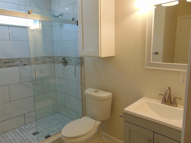 bathroom featuring vanity, a shower with shower door, and toilet