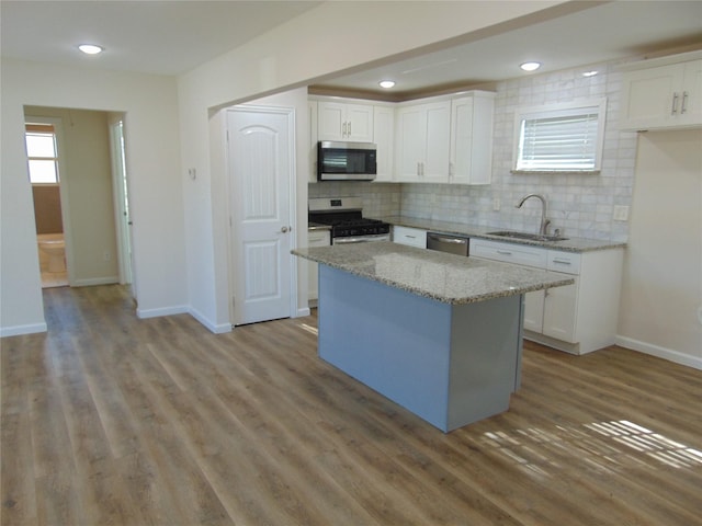 kitchen featuring sink, white cabinetry, tasteful backsplash, a kitchen island, and appliances with stainless steel finishes