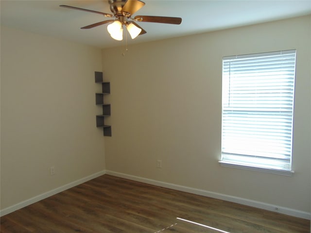 empty room featuring a healthy amount of sunlight, ceiling fan, and dark hardwood / wood-style floors