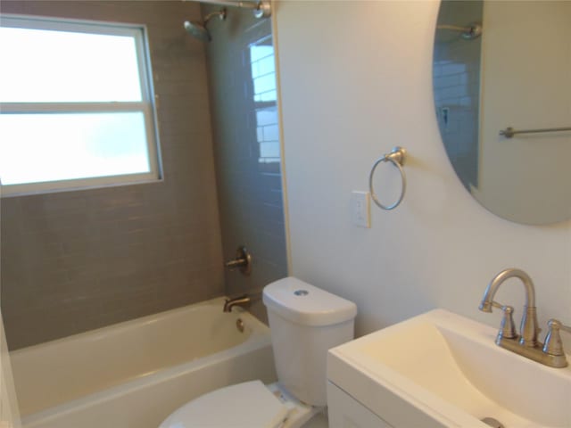 full bathroom with vanity, a wealth of natural light, tiled shower / bath combo, and toilet