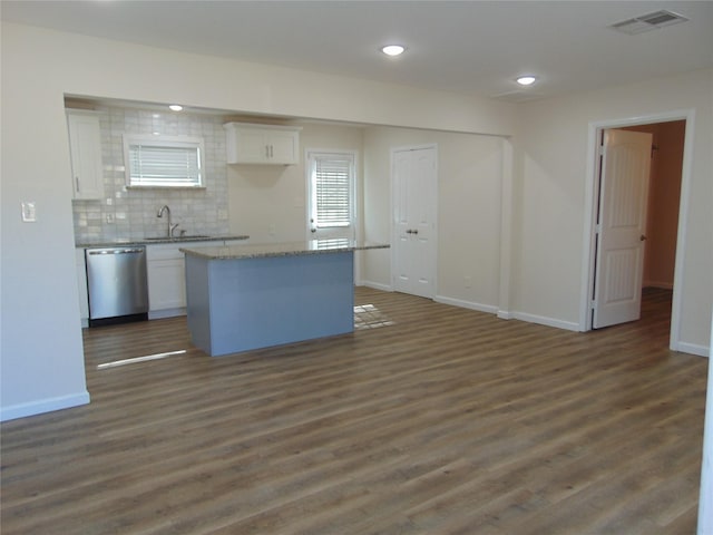 kitchen with dishwasher, decorative backsplash, a kitchen island, white cabinets, and sink