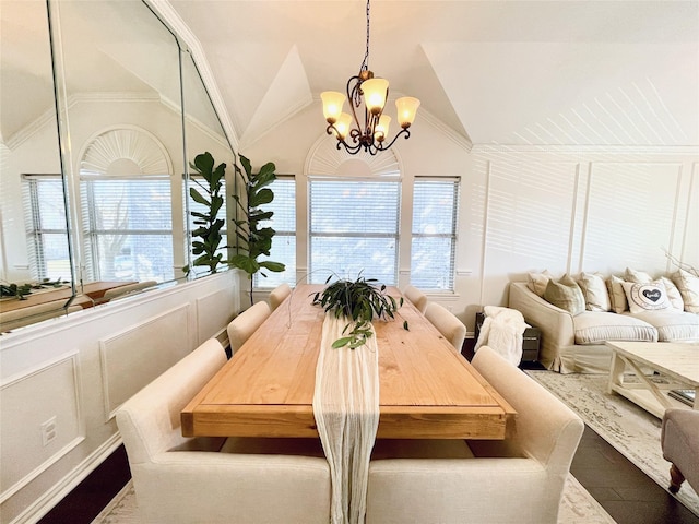 dining space featuring a notable chandelier, vaulted ceiling, and crown molding