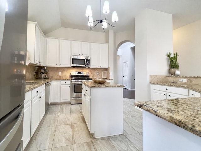 kitchen with decorative light fixtures, stainless steel appliances, light stone countertops, and white cabinetry