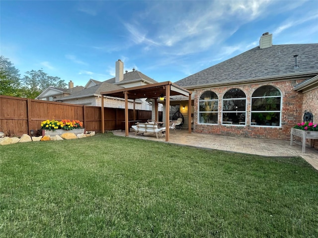 back of property with a lawn and a patio area