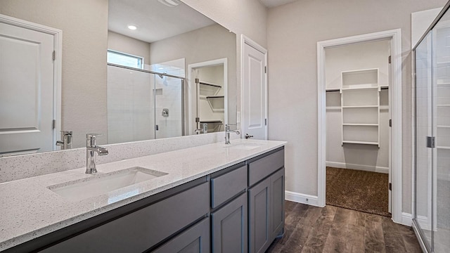 bathroom with hardwood / wood-style flooring, walk in shower, and vanity