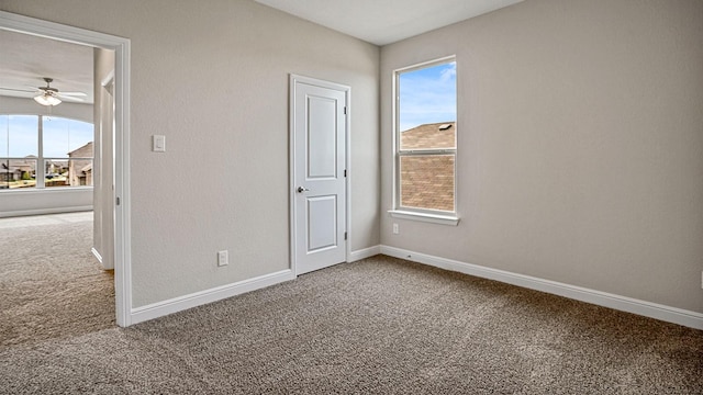 carpeted empty room featuring a healthy amount of sunlight and ceiling fan