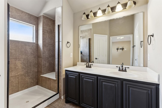 bathroom featuring a tile shower, tile patterned floors, and vanity