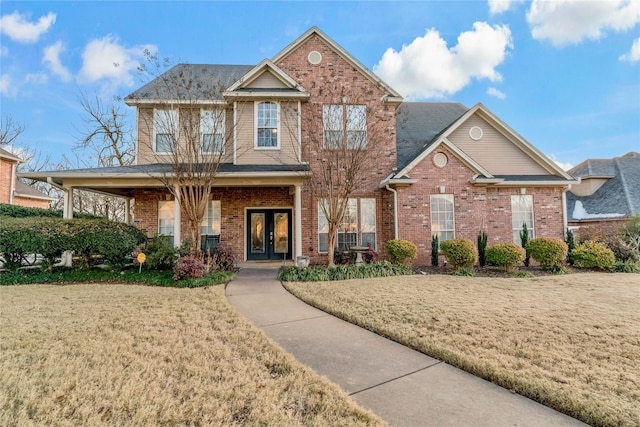 view of front of home with french doors and a front lawn