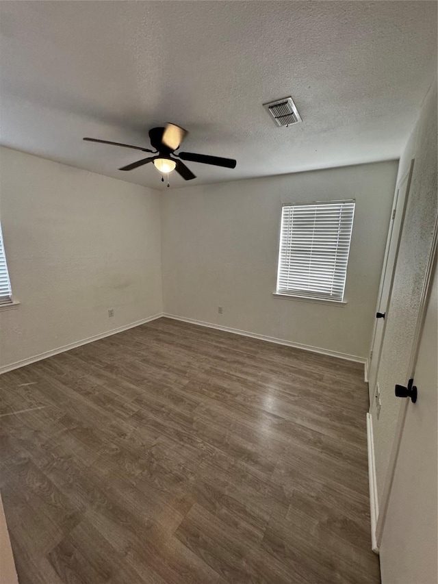 unfurnished room with dark wood-type flooring, a textured ceiling, and ceiling fan