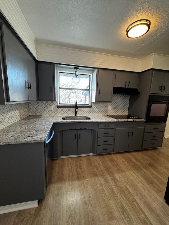 kitchen featuring sink, a textured ceiling, light stone countertops, black appliances, and gray cabinetry